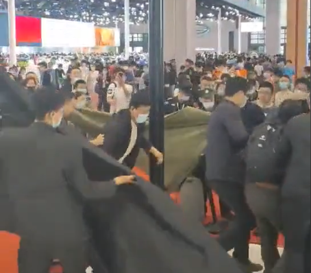 上海车展特斯拉展台再现维权：黑布、黑伞齐上阵 维权者被大汉秒制服